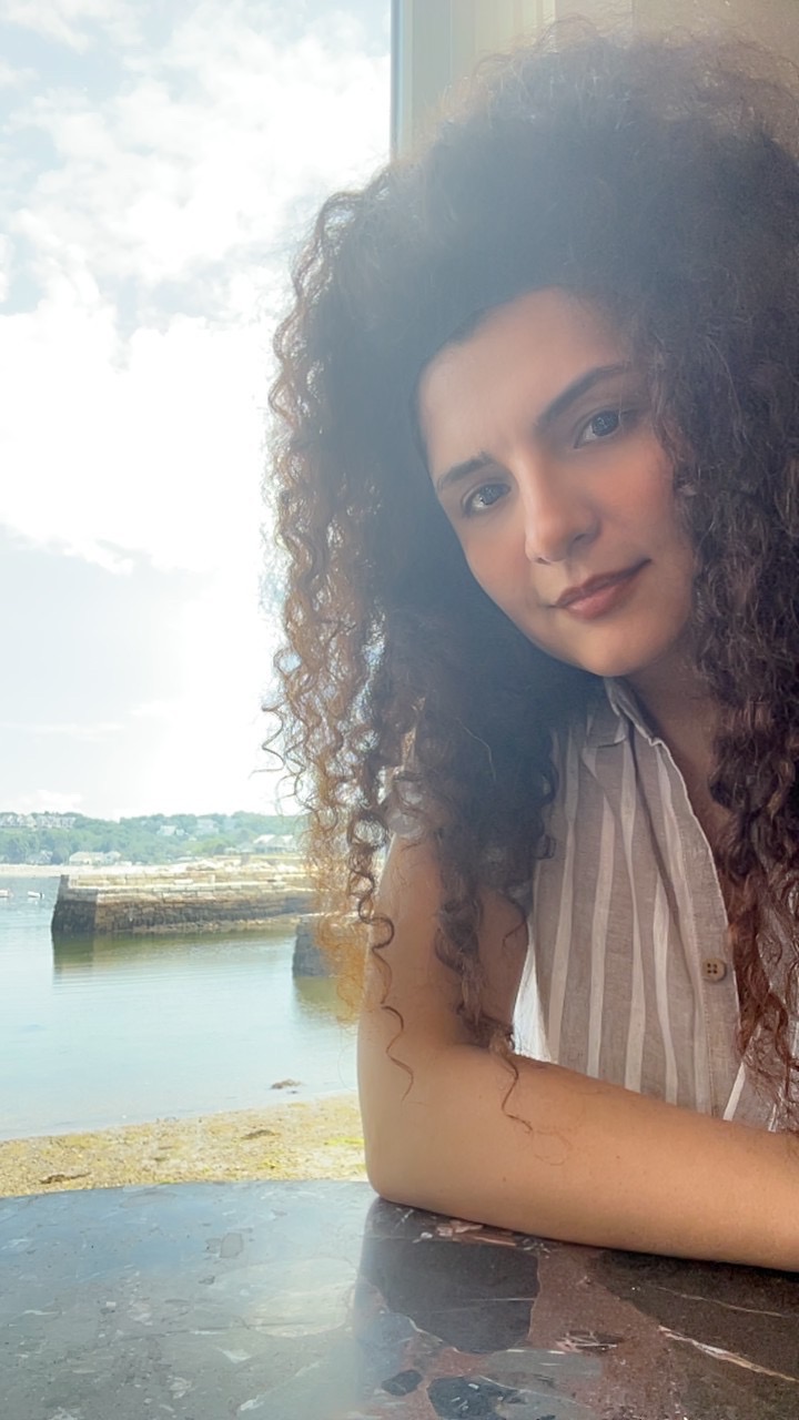 The founder of Replace Scrolling sitting by a window overlooking the water